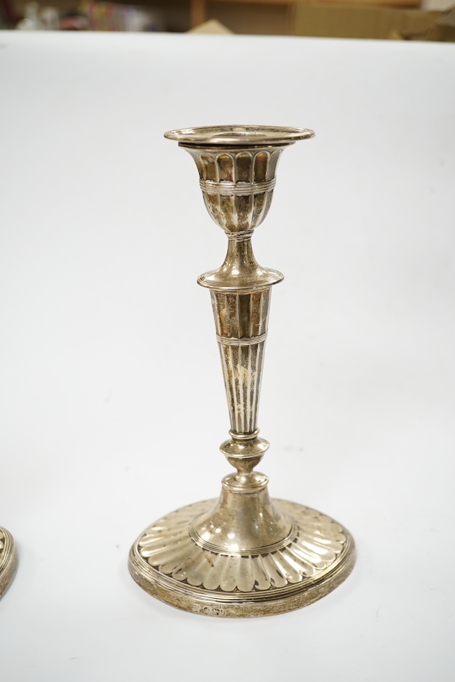 A matched pair of Edwardian silver oval candlesticks, Hawksworth, Eyre & Co and Goldsmiths & Silversmiths Co Ltd, height 21.9cm, weighted. Condition - fair